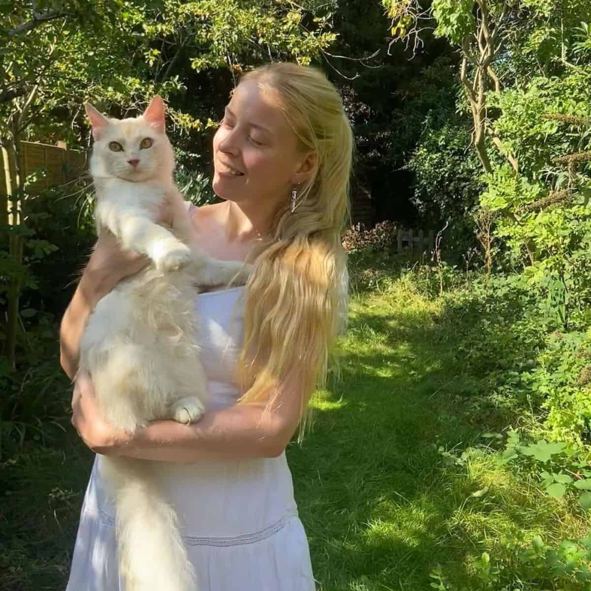 blond woman with cat in arms