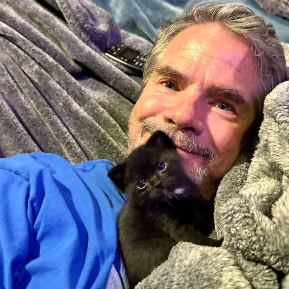 close-up photo of man and kitten