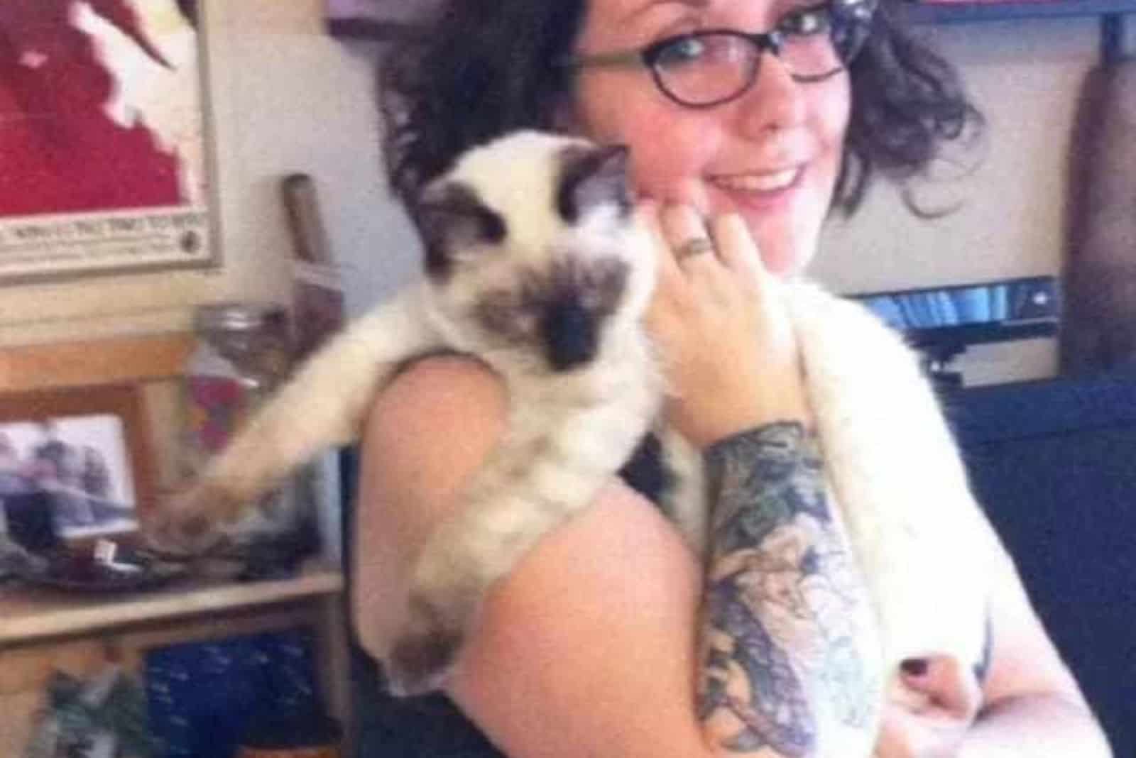 girl with glasses holding a kitten