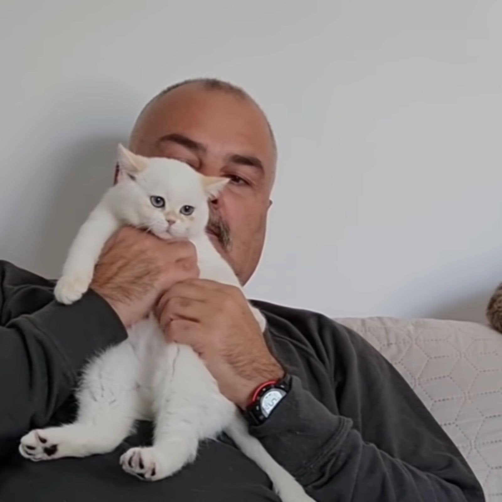old guy holding white kitten