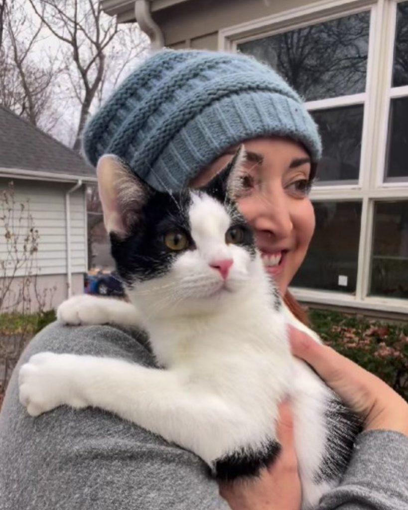 smiling girl outdoors with a cat in her arms