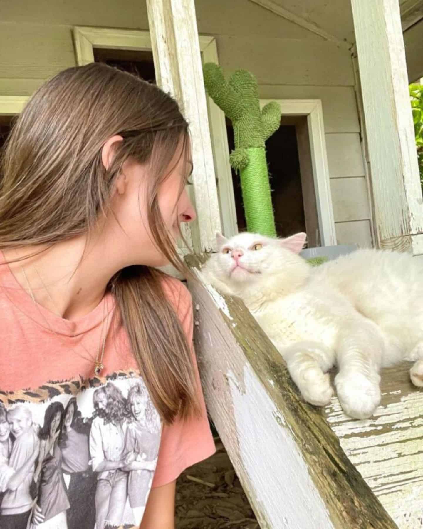the girl and the cat look at each other with love