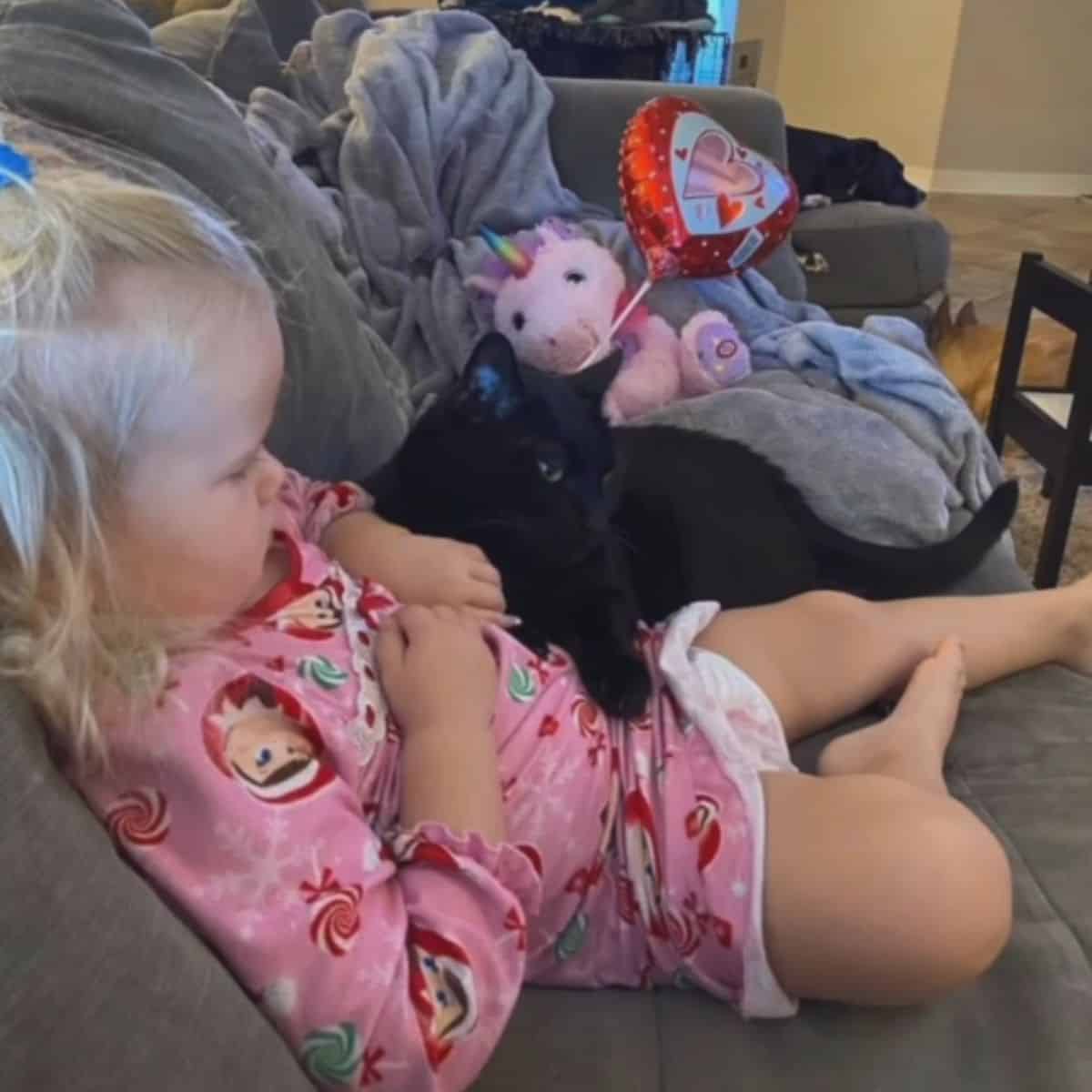 little girl with cat on couch