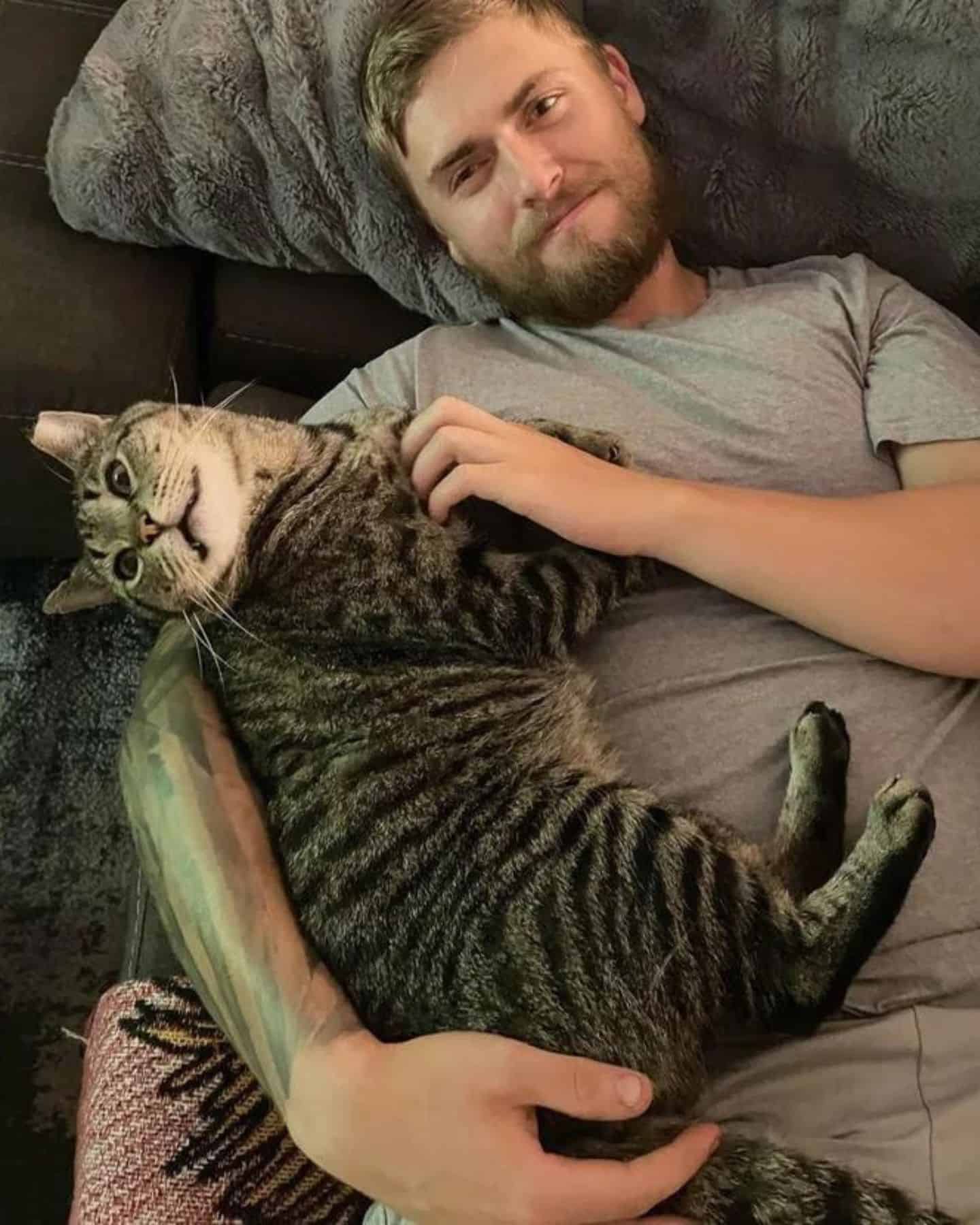 man and cat lying together