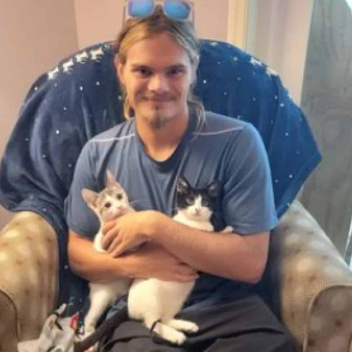 man holding two kittens