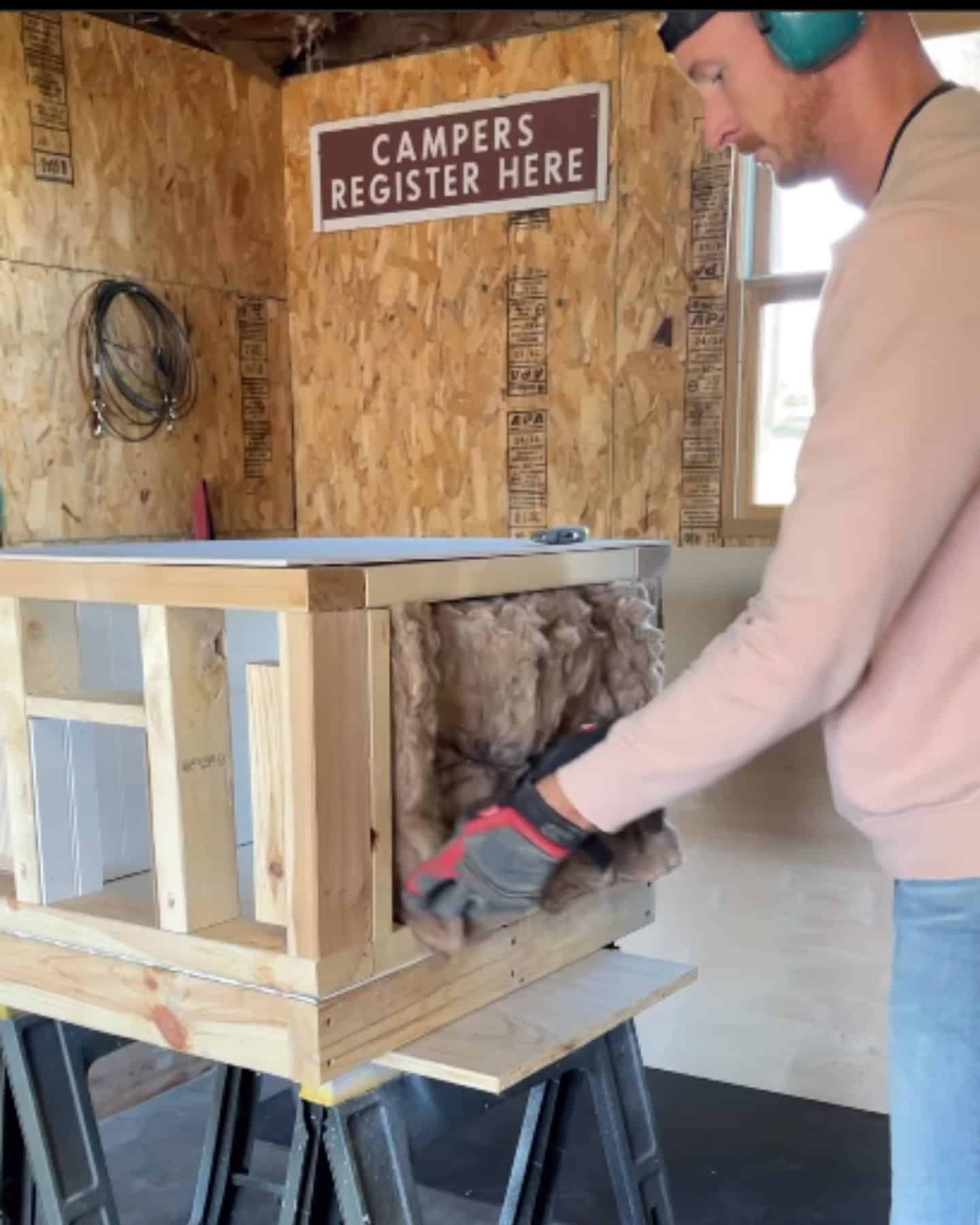 photo of man building insulated cat house