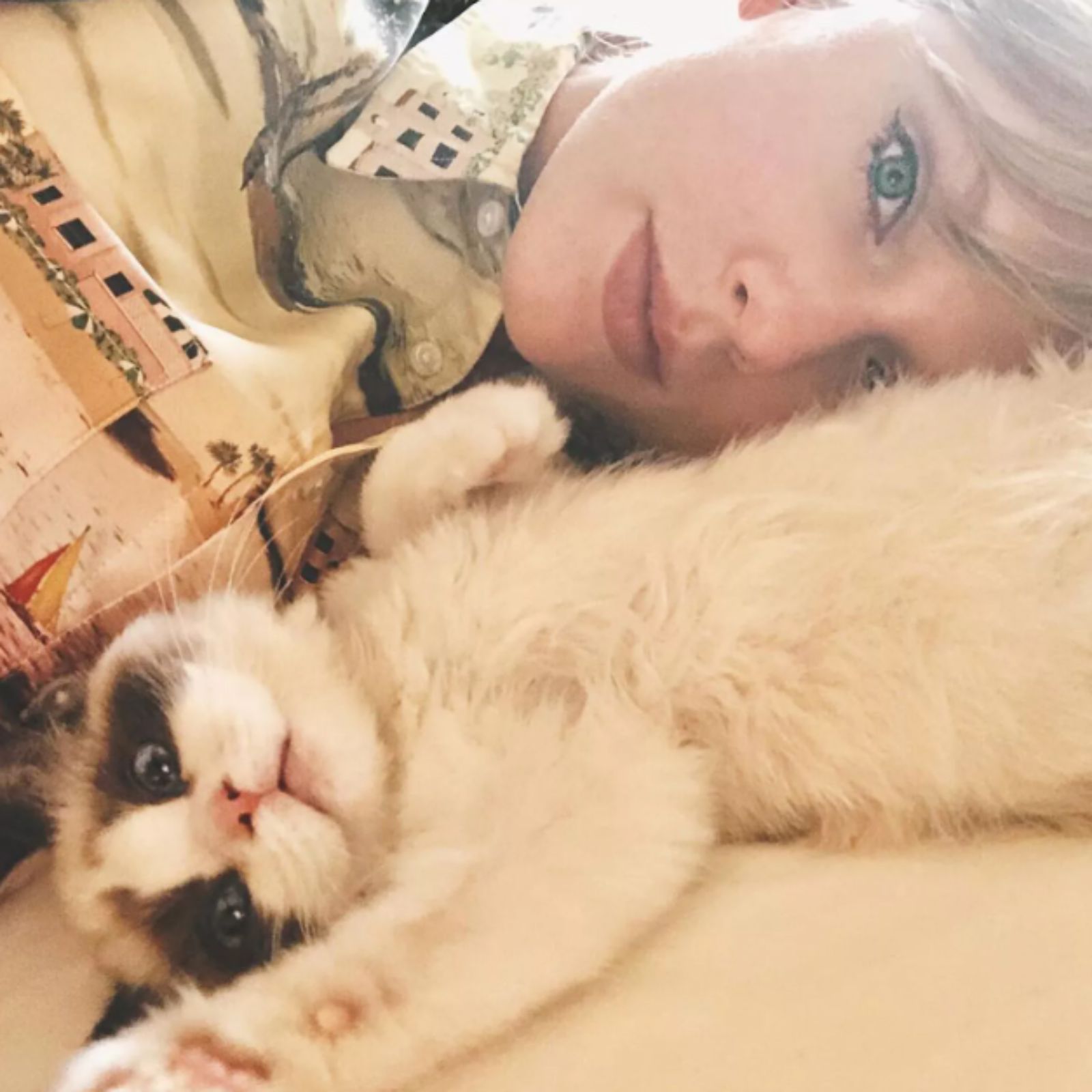 photo of taylor swift lying with a cat