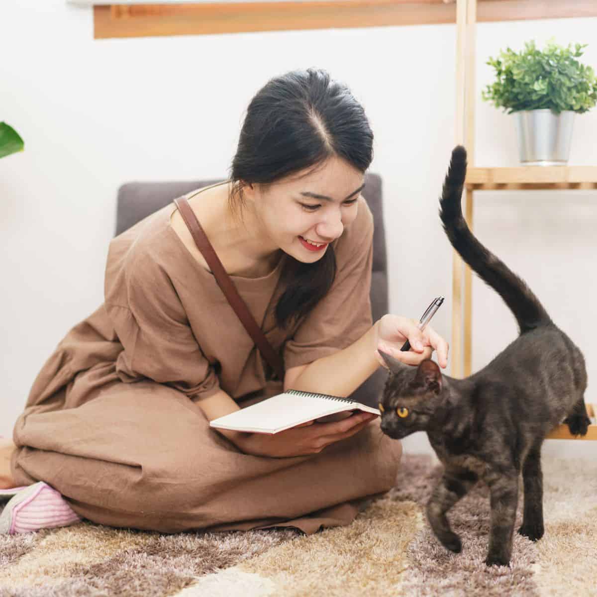 smiling woman reading to the cat