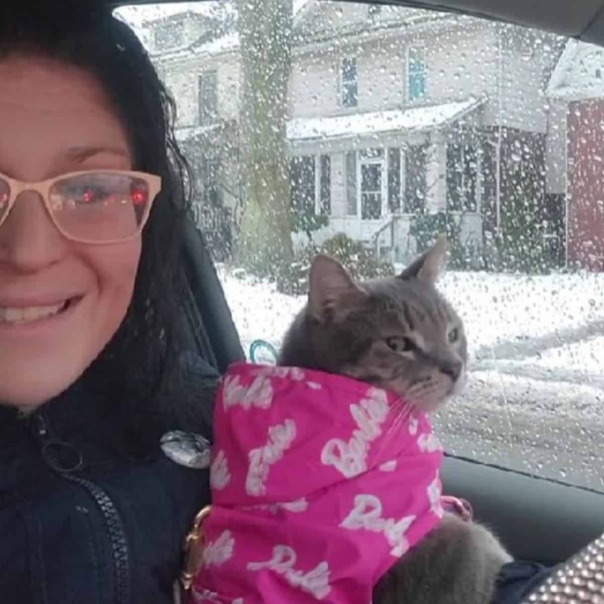 woman holding a cat with barbie jacket