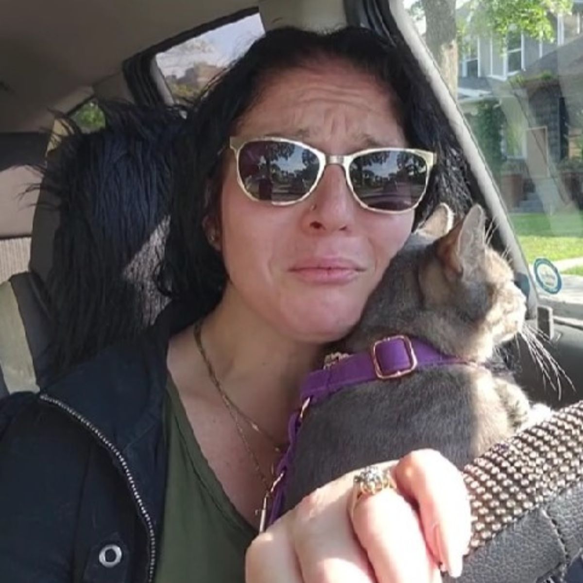 woman holding the cat while driving
