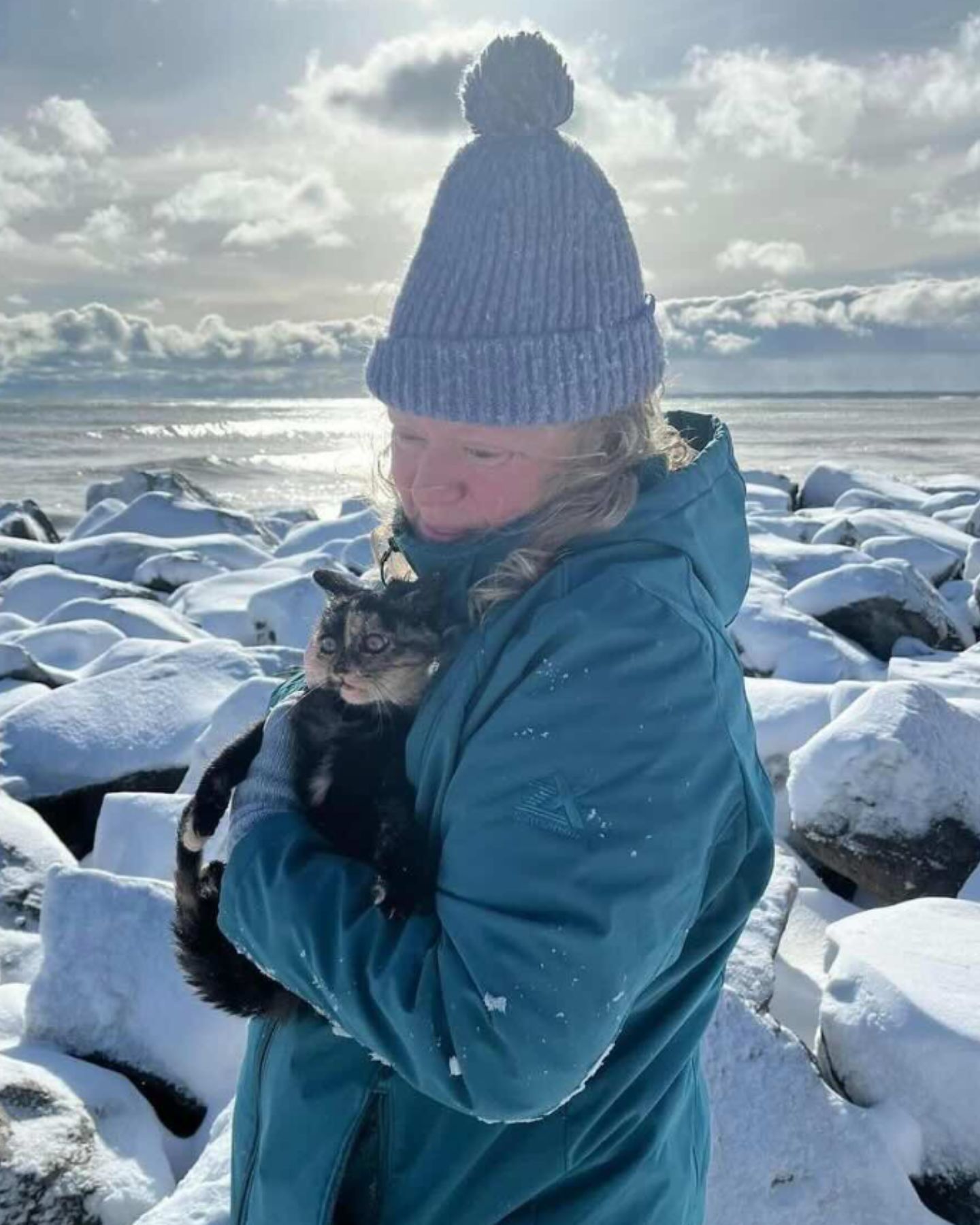 granny holding cat on snow