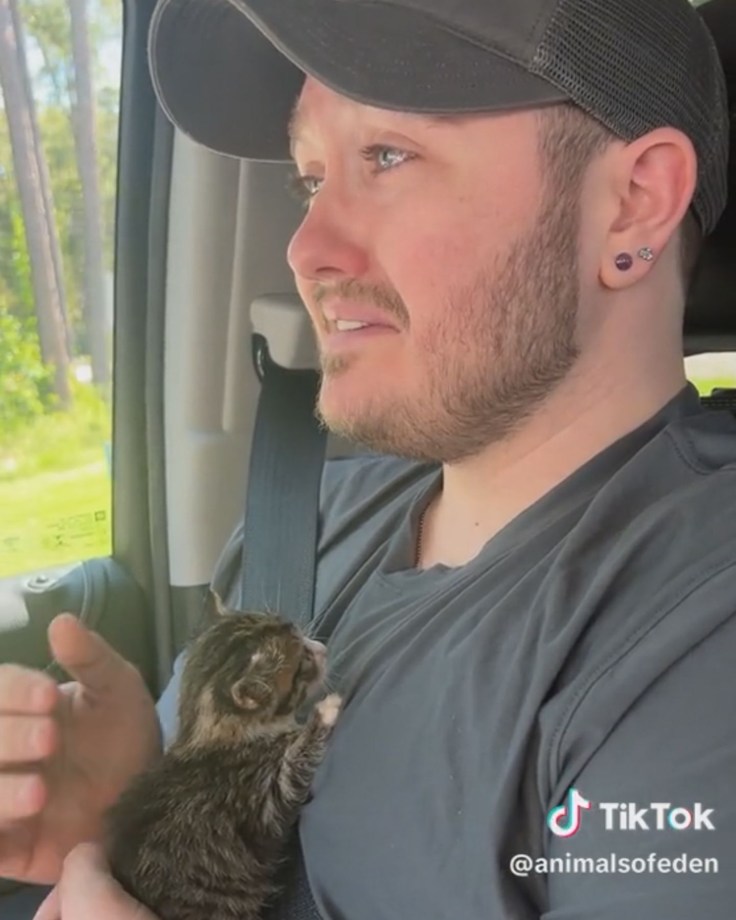 man in a car holding a kitten