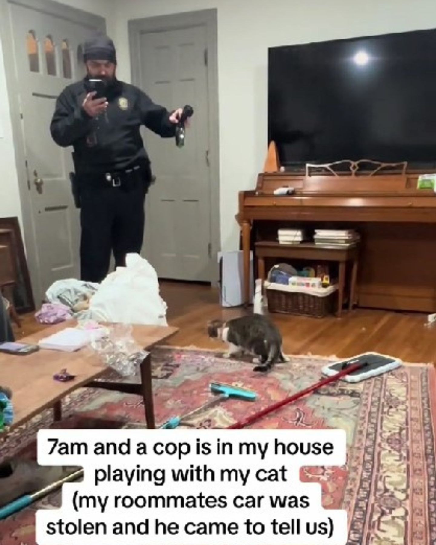 photo of police officer playing with cat