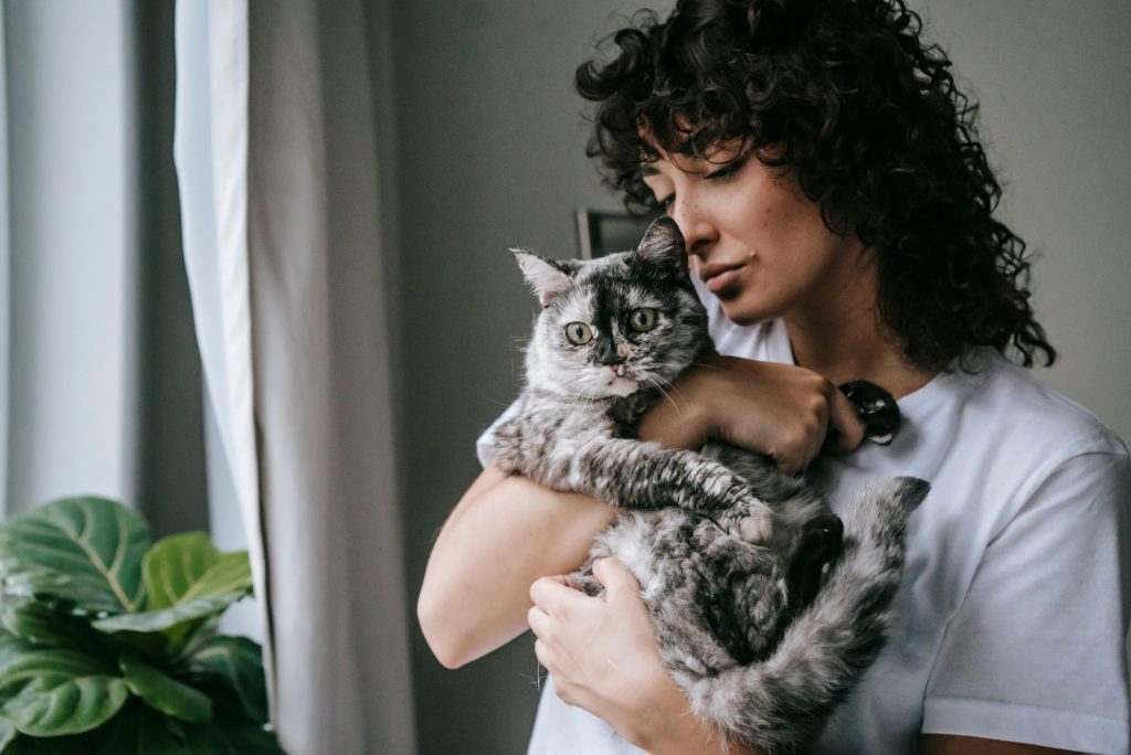 woman hugging her gray cat