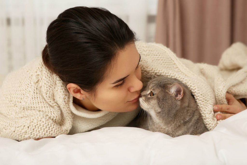 woman kissing cats nose