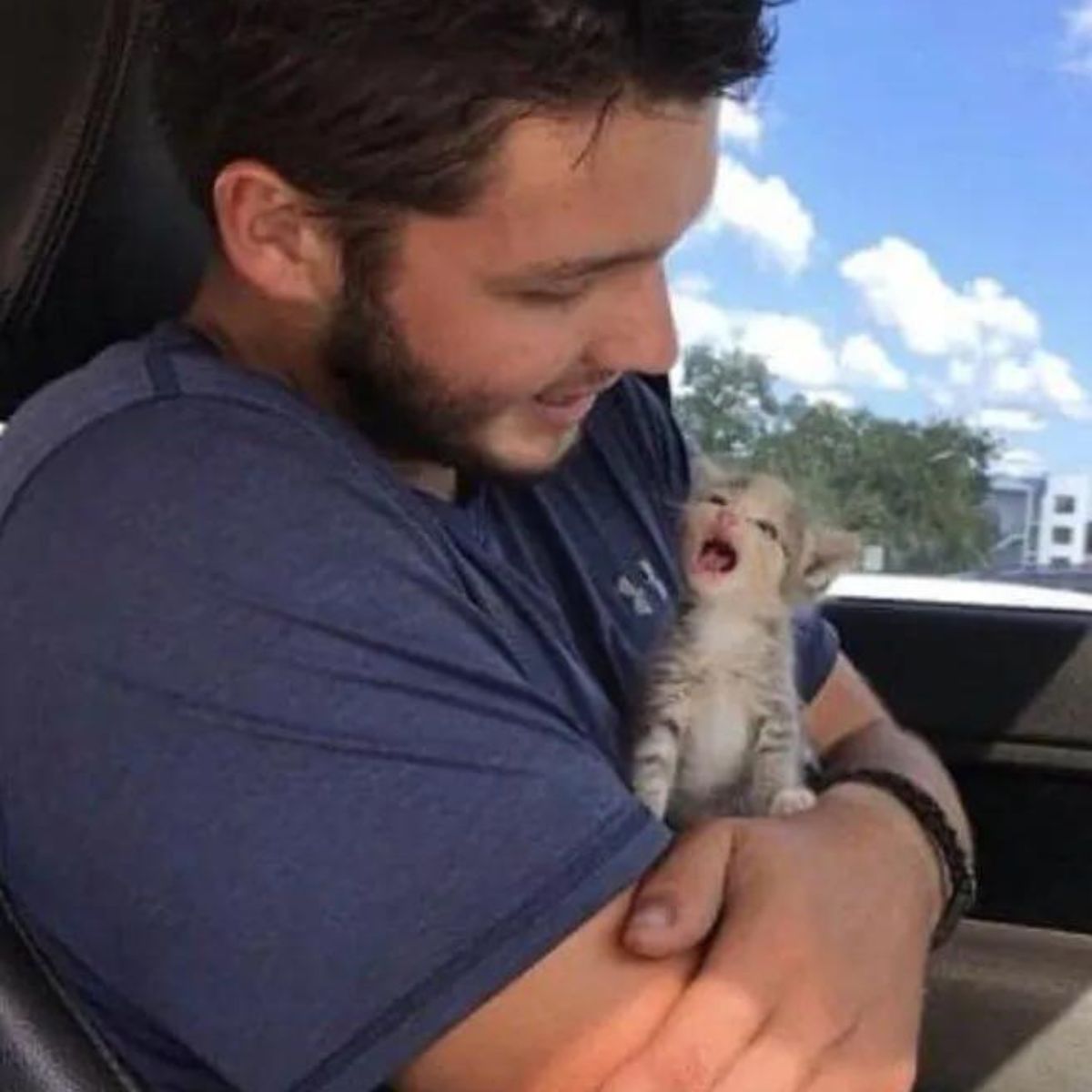 guy in a car holding a kitten