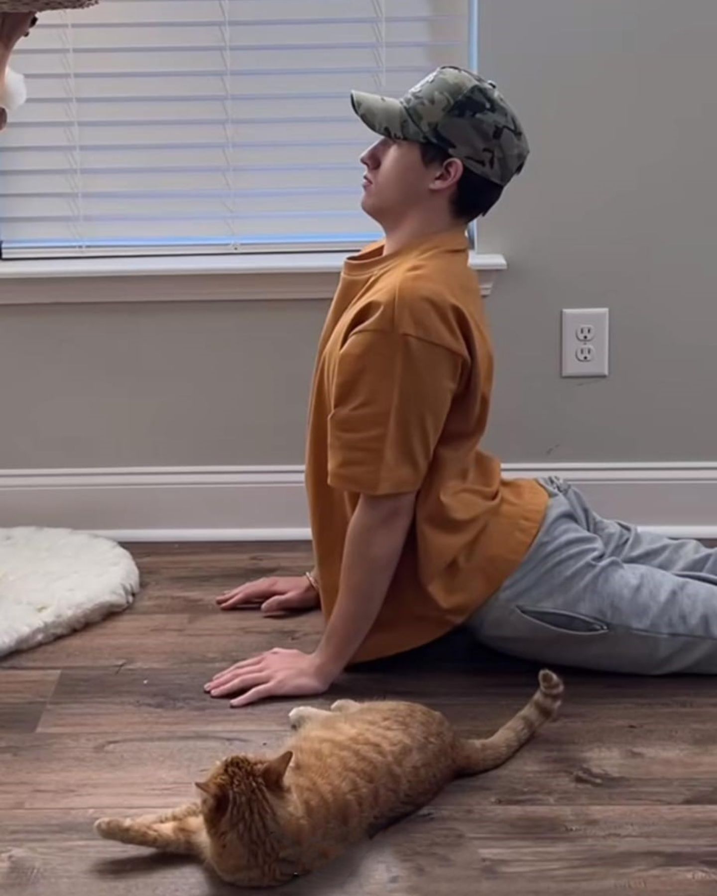 man stretching with cat