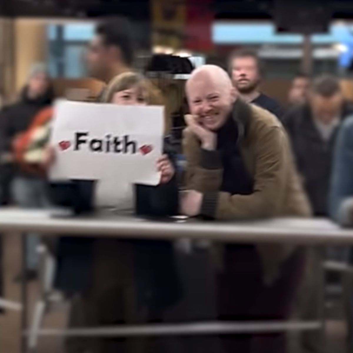 couple holdin a sign saying faith