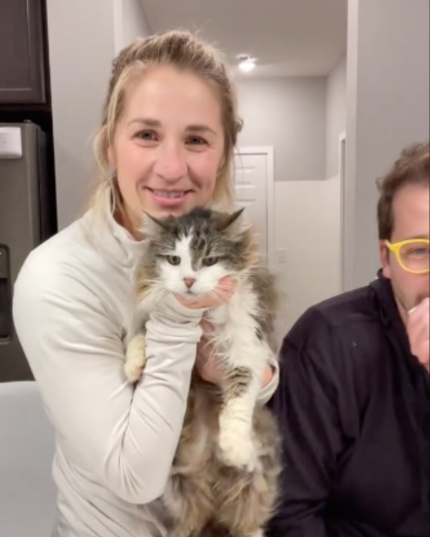 smiling blond woman holding a cat