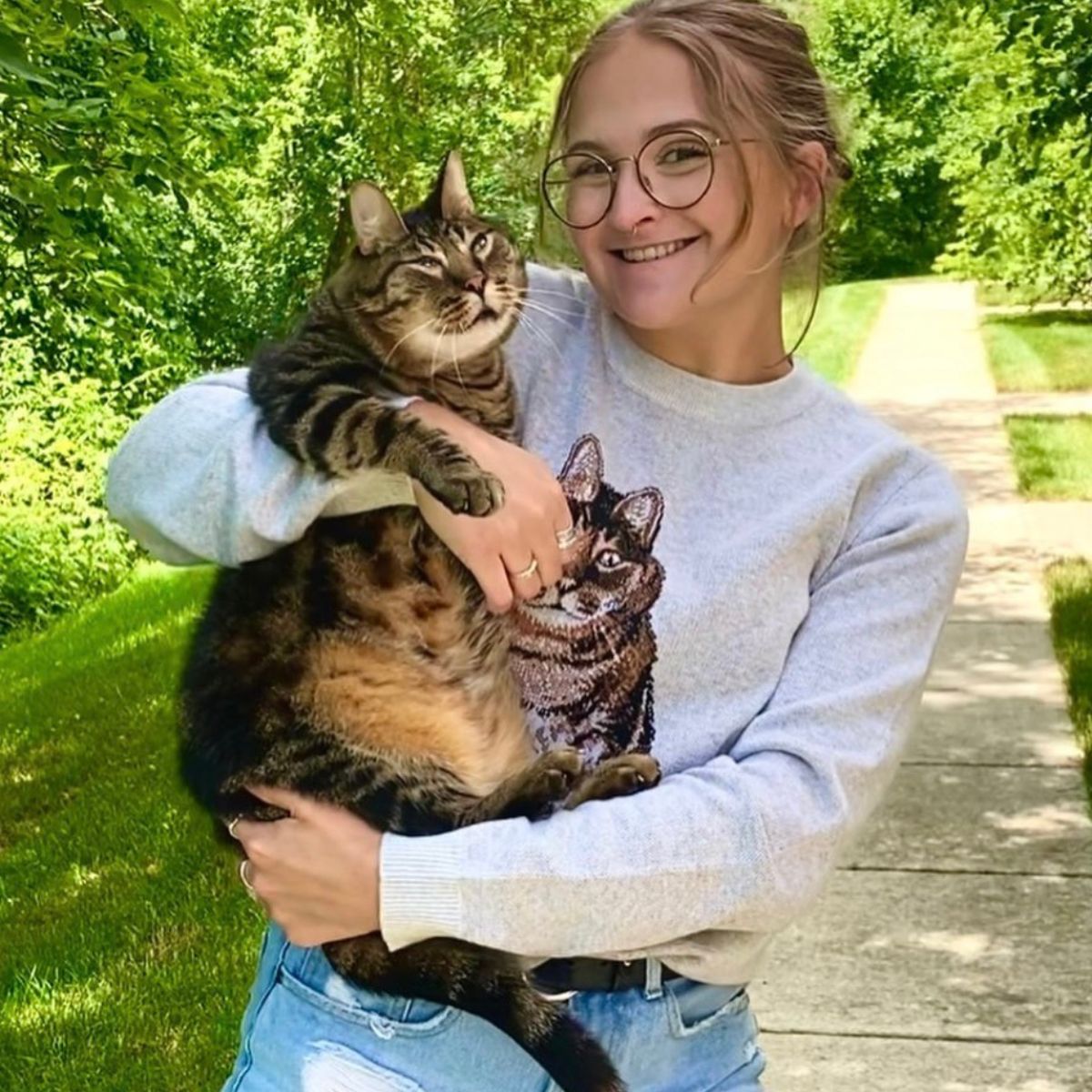 smiling woman with glasses holds a cat