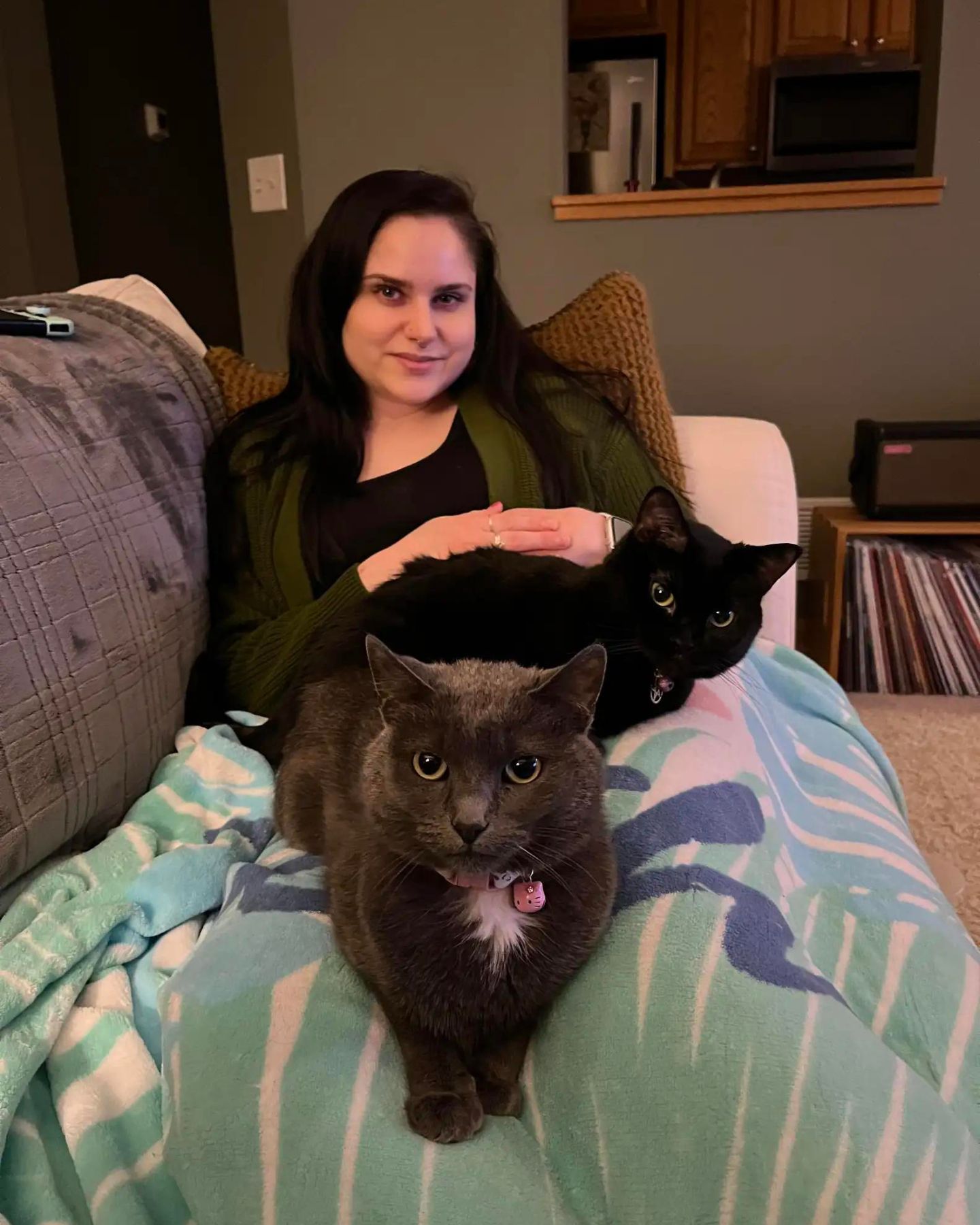 two cats laying on a woman