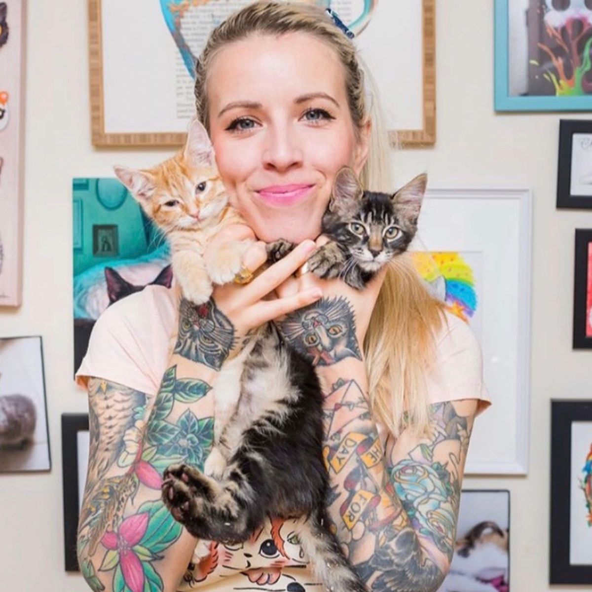 woman with tattoos holding kittens