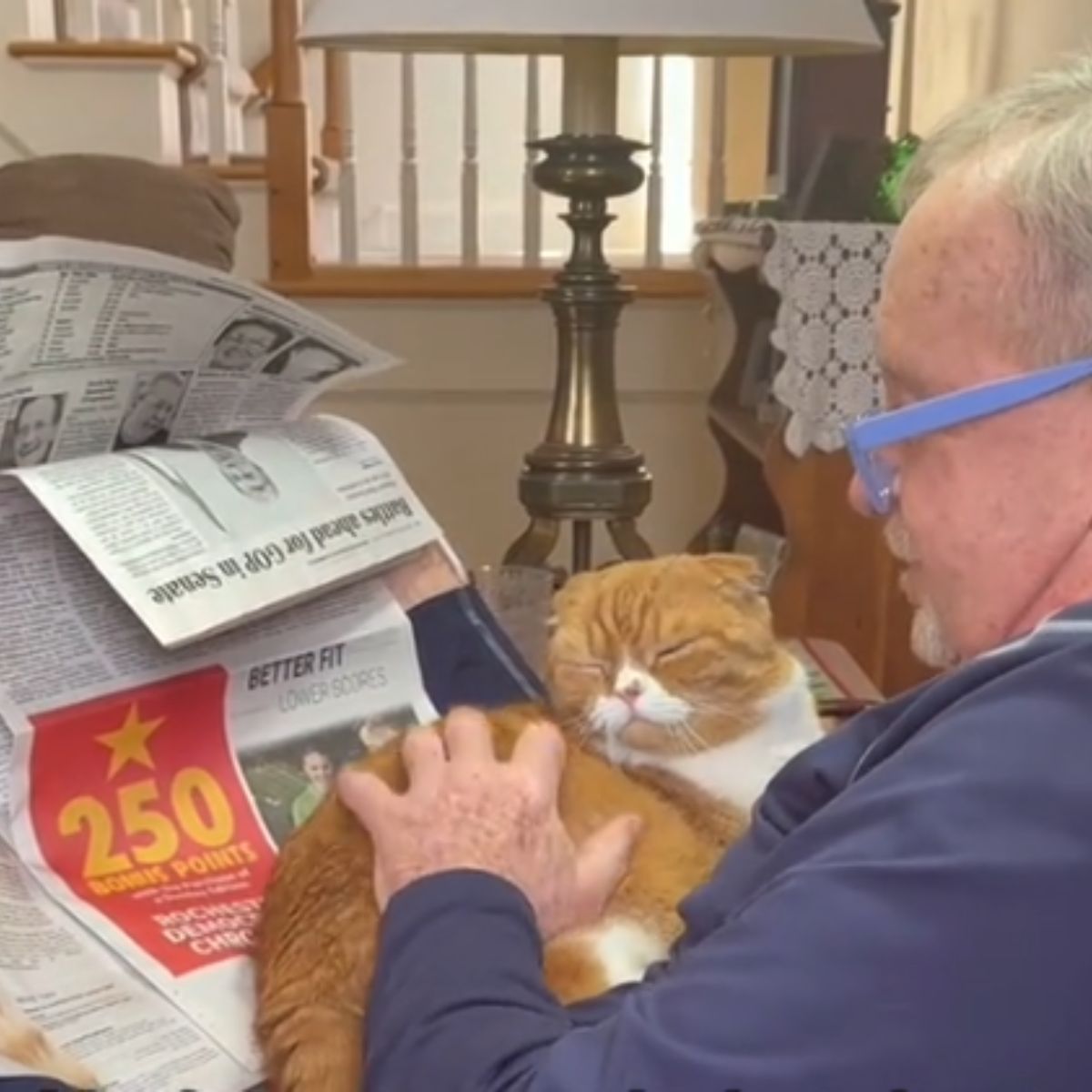 a man reading newspaper with cat
