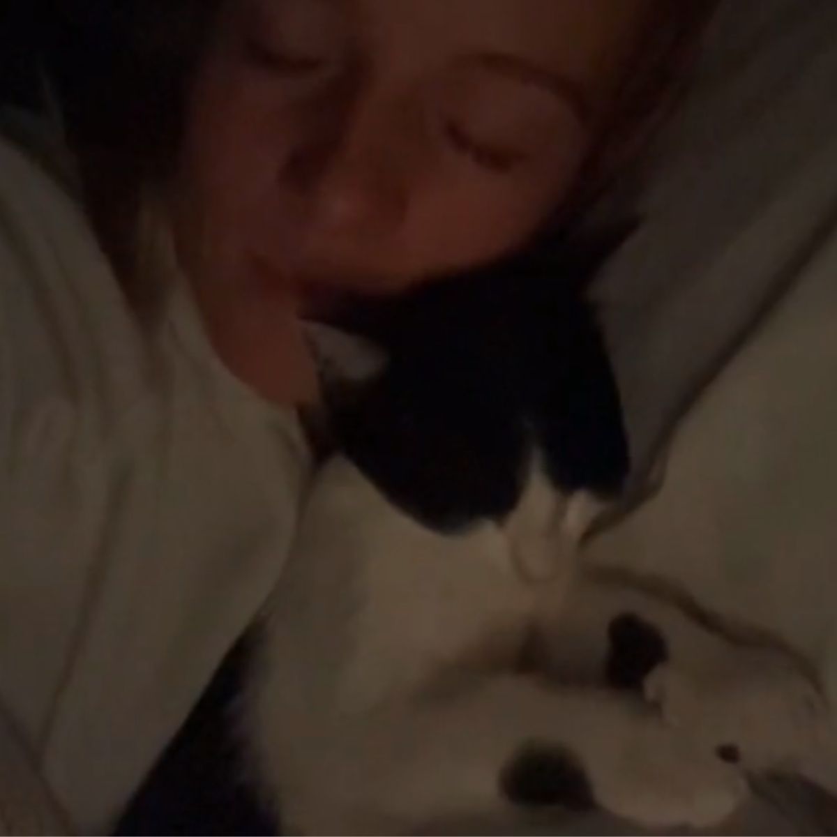 woman and cat snuggled up sleeping