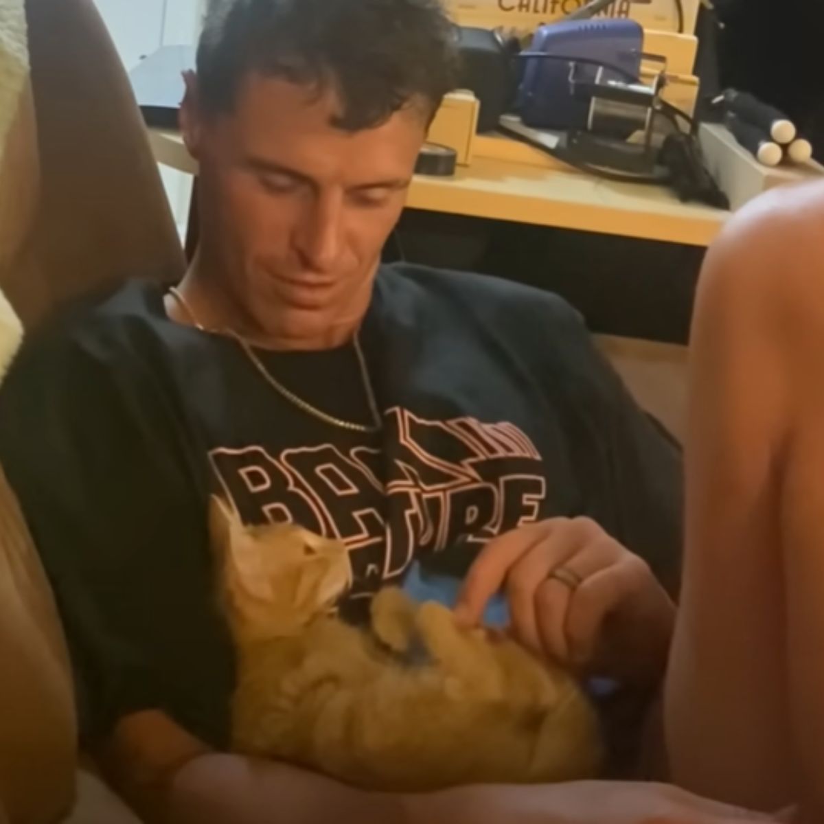 man cuddling with cat