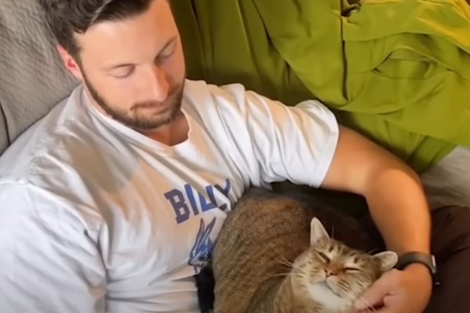 man sitting next to a cat