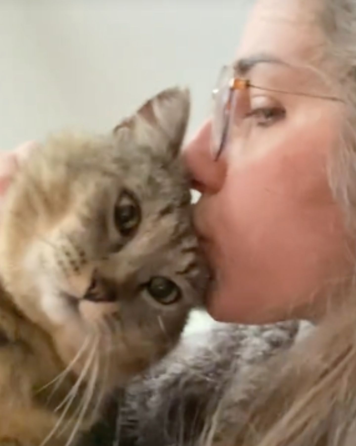 woman kissing the bobcat