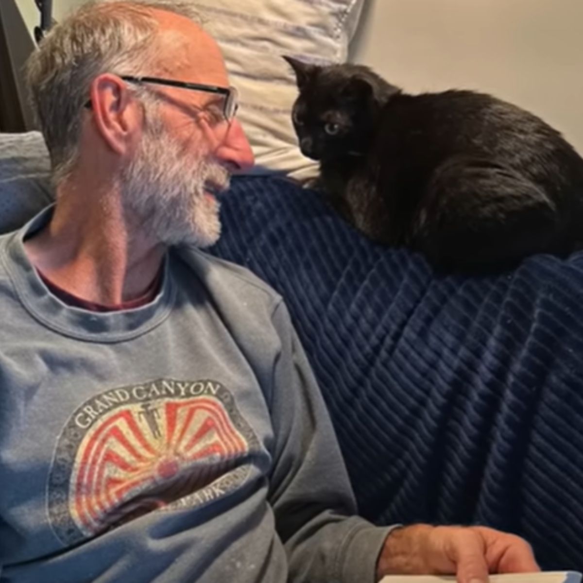 man and cat sitting on couch