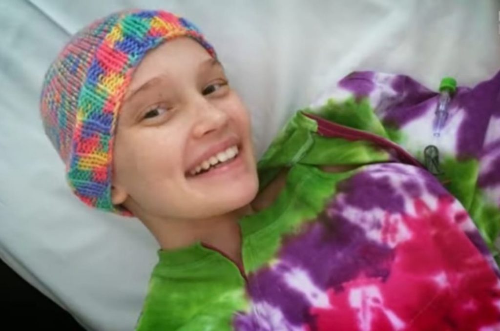 smiling sick girl with a colorful cap on her head