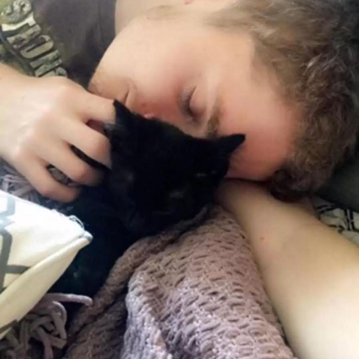 man cuddling with cat