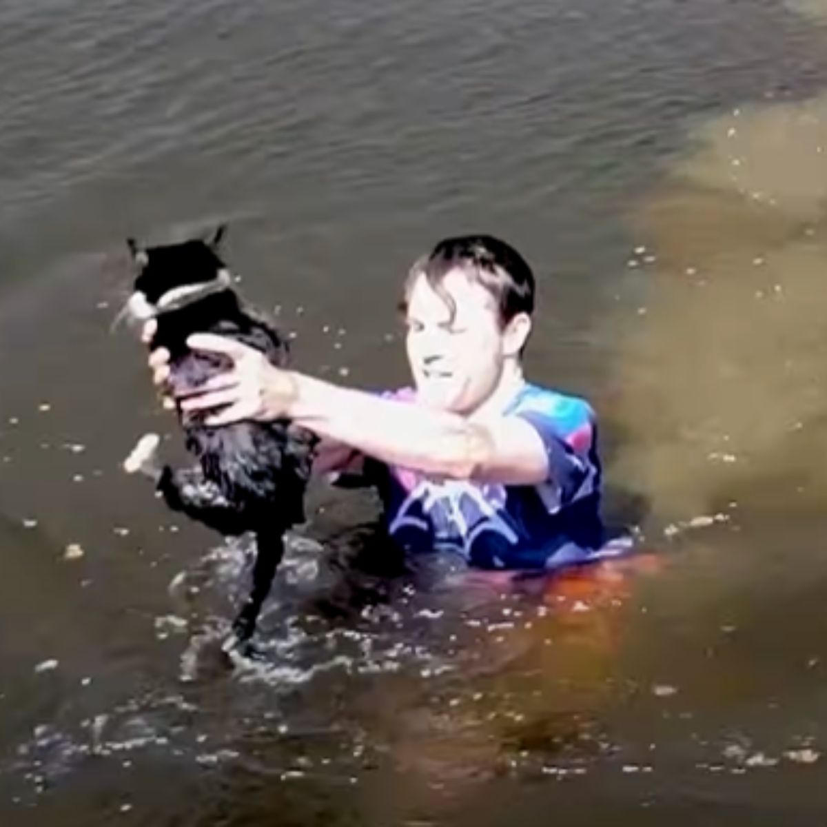 man holding cat above water