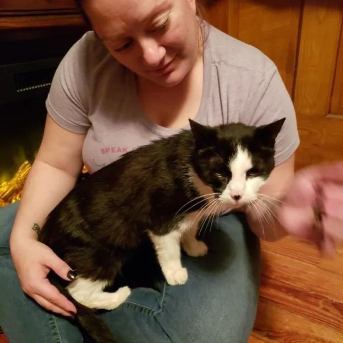 woman holding a black and white cat