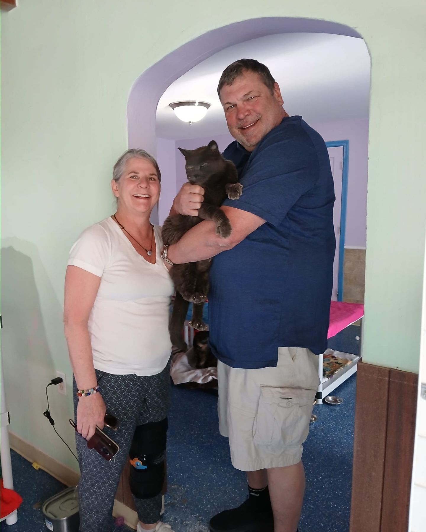 happy senior couple posing with cat