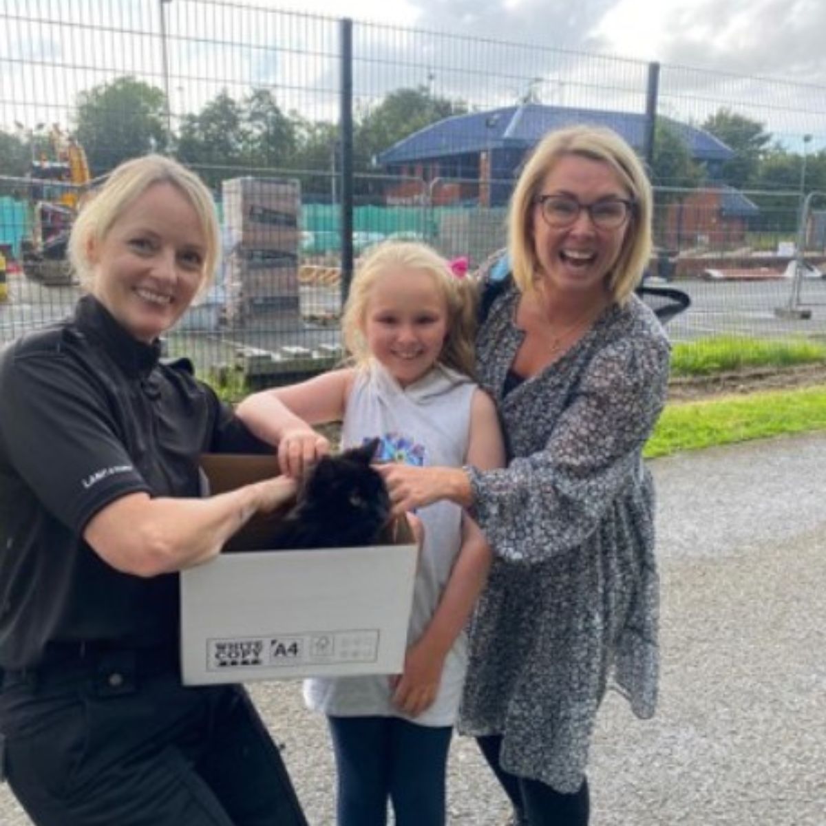 happy women and a girl with cat in cardbox