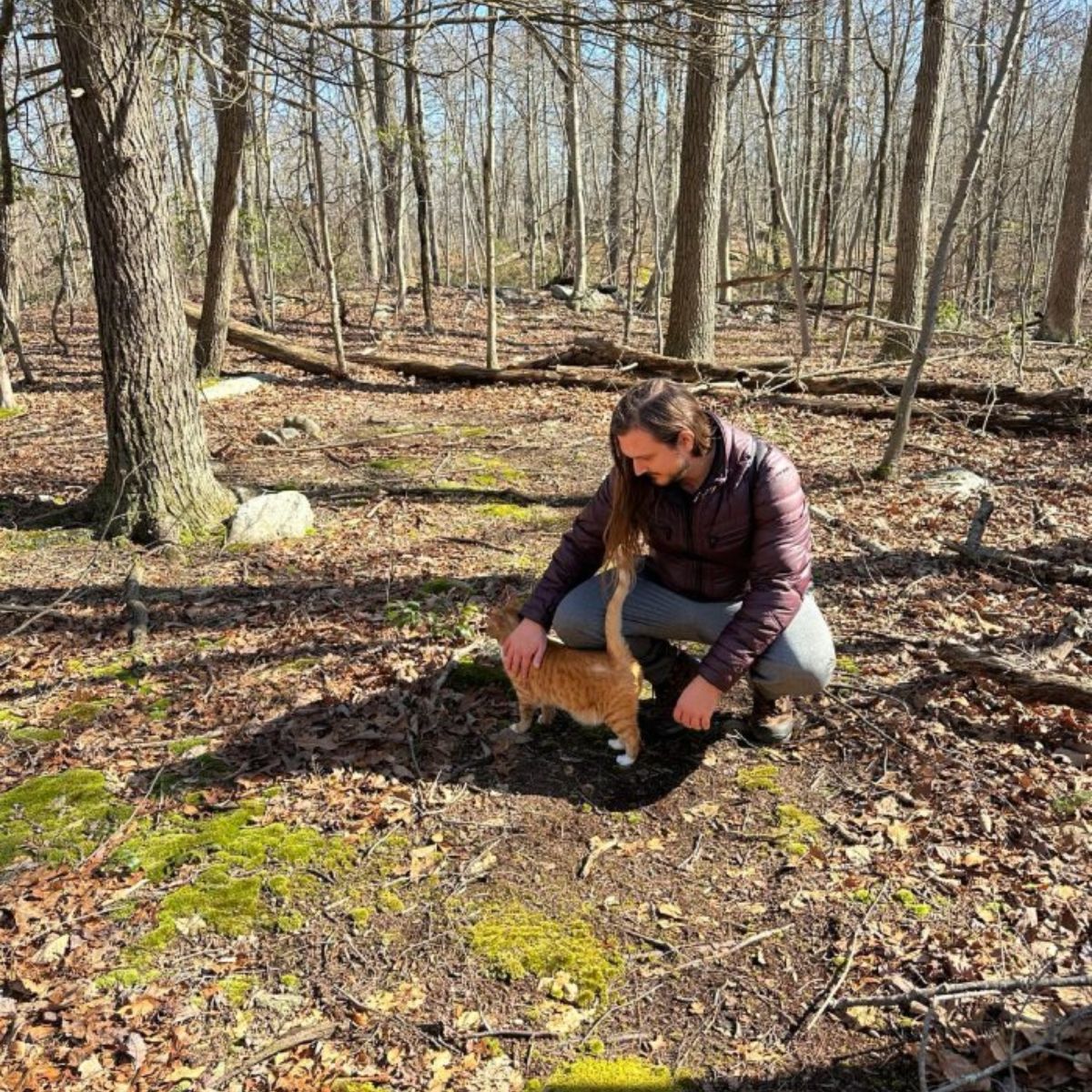 man and cat in the woods