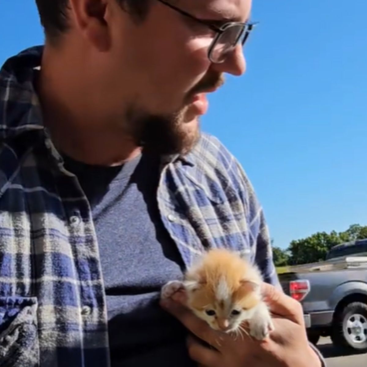 a man holding tiny kitten