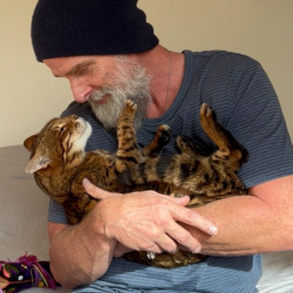 a man holds a cat in his arms