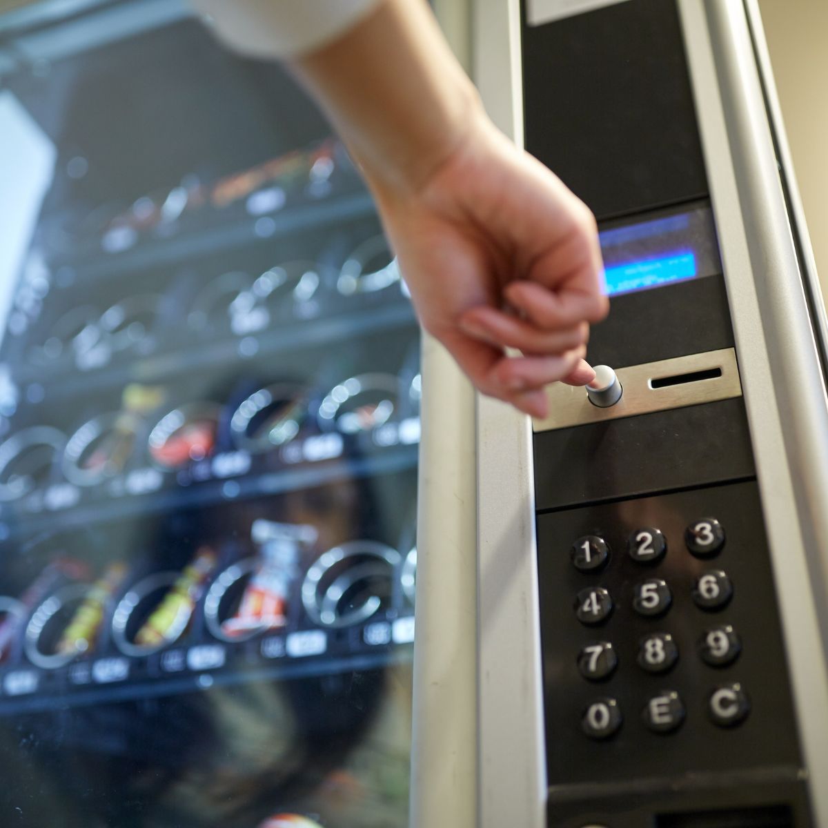 hand pressing buttons on vending machine