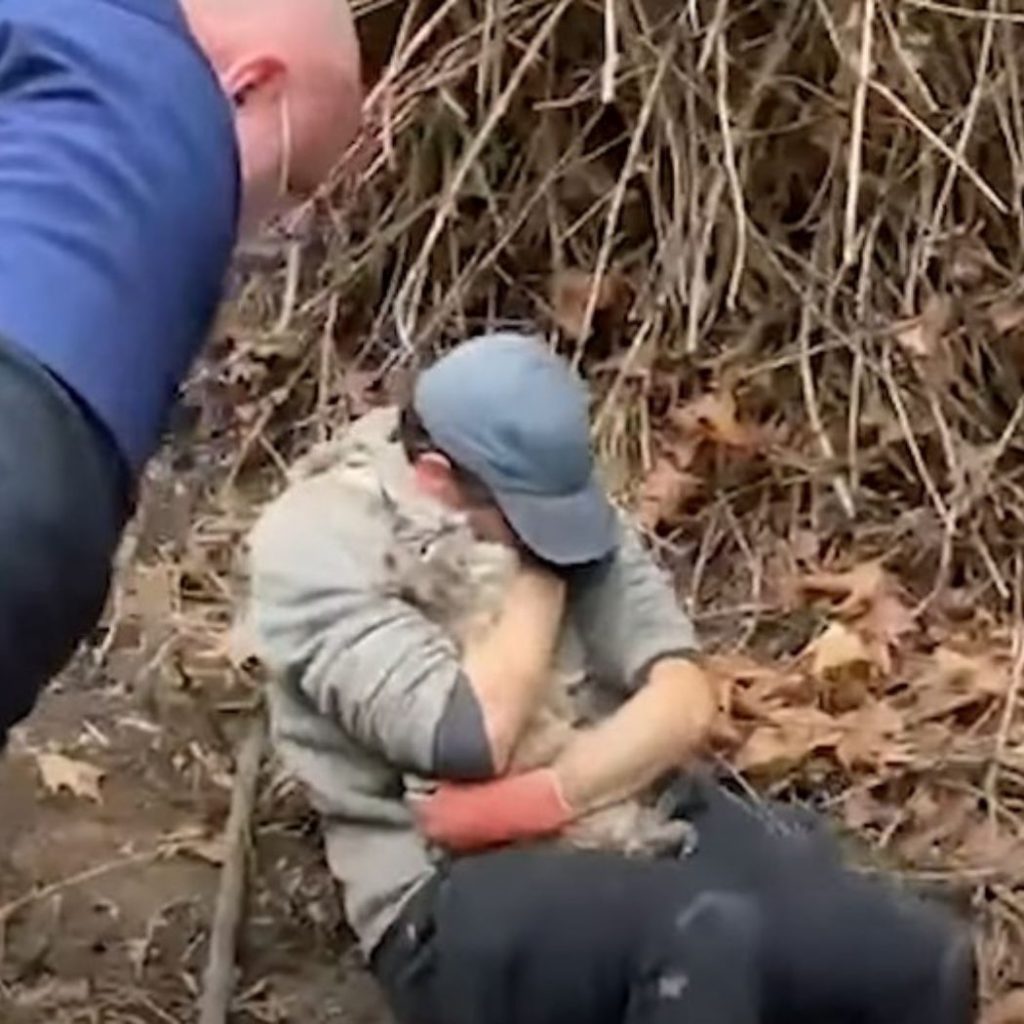 man hugs cat after rescue