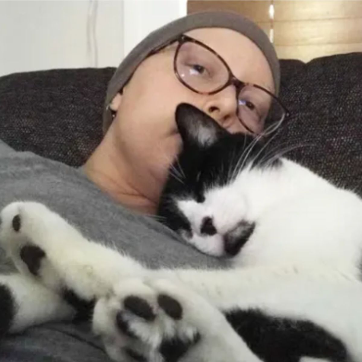 sick woman with cat on her chest