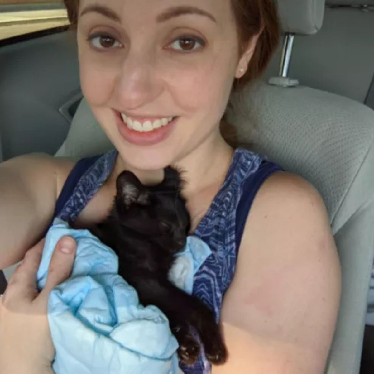 woman holding a black kitten