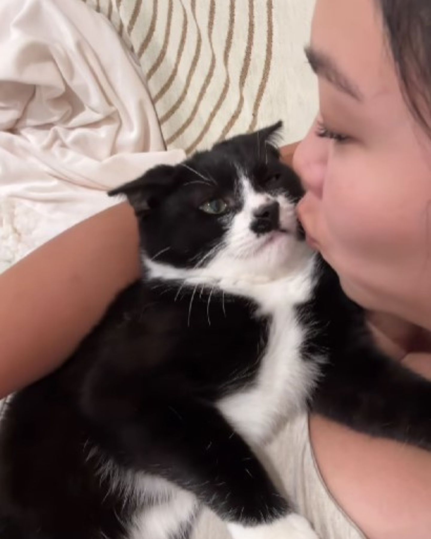 woman kissing cat