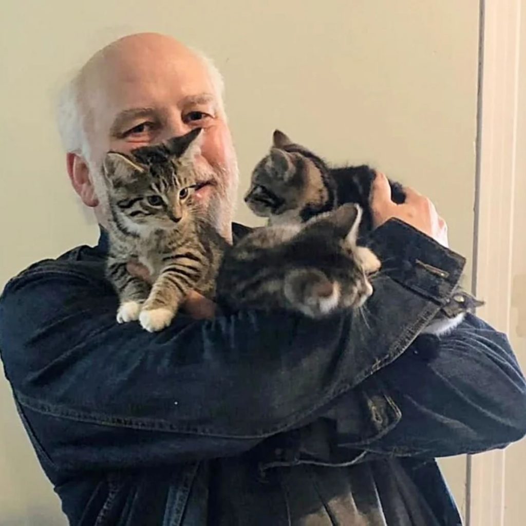 a man holds kittens in his arms