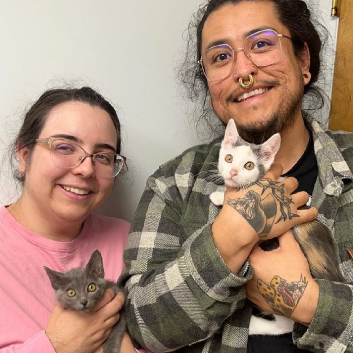 man and woman each holding a kitten