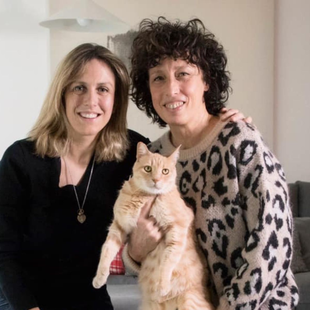 two women posing with cat