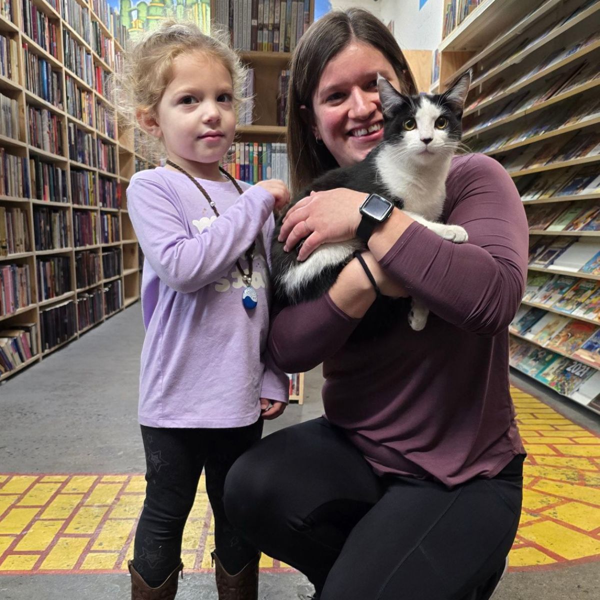 little girl and woman holding a cat